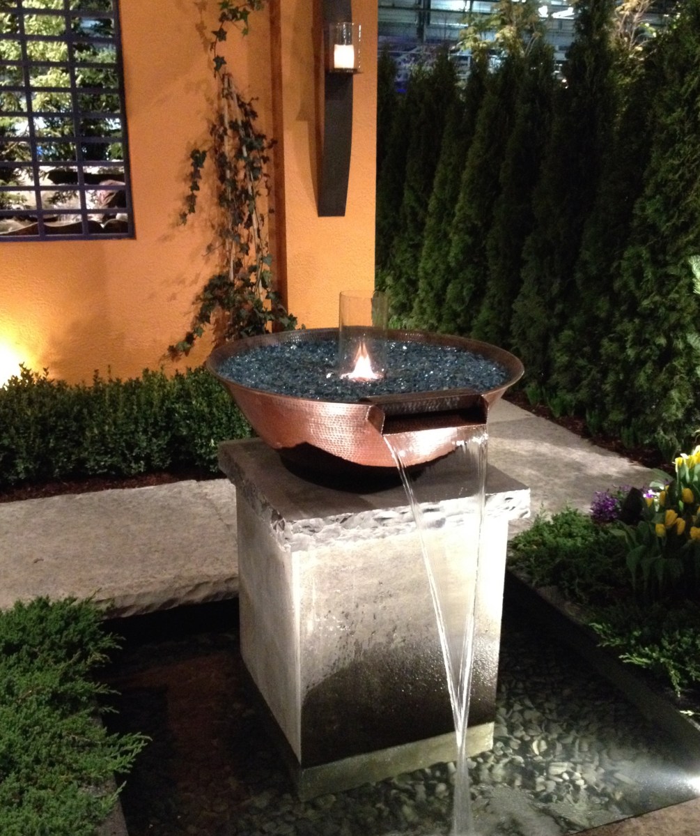 Garden sculpture with waterfall and open flame.