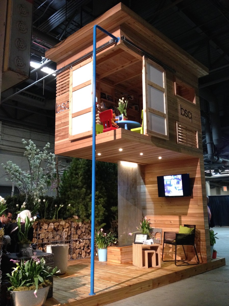 Front view of a wooden room held aloft by a panel support.
