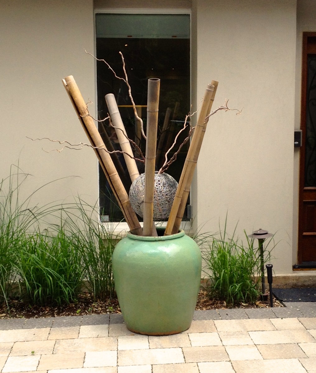 A plant container is filled with poles and twigs.