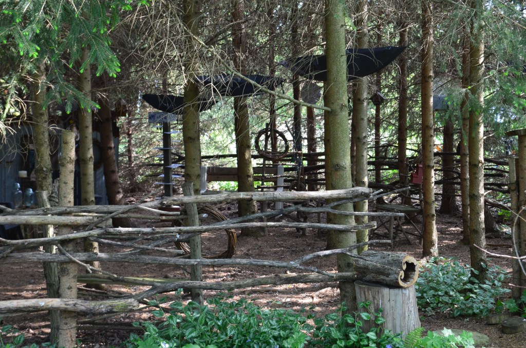 A shady grove for seating includes found art and suspended umbrellas.