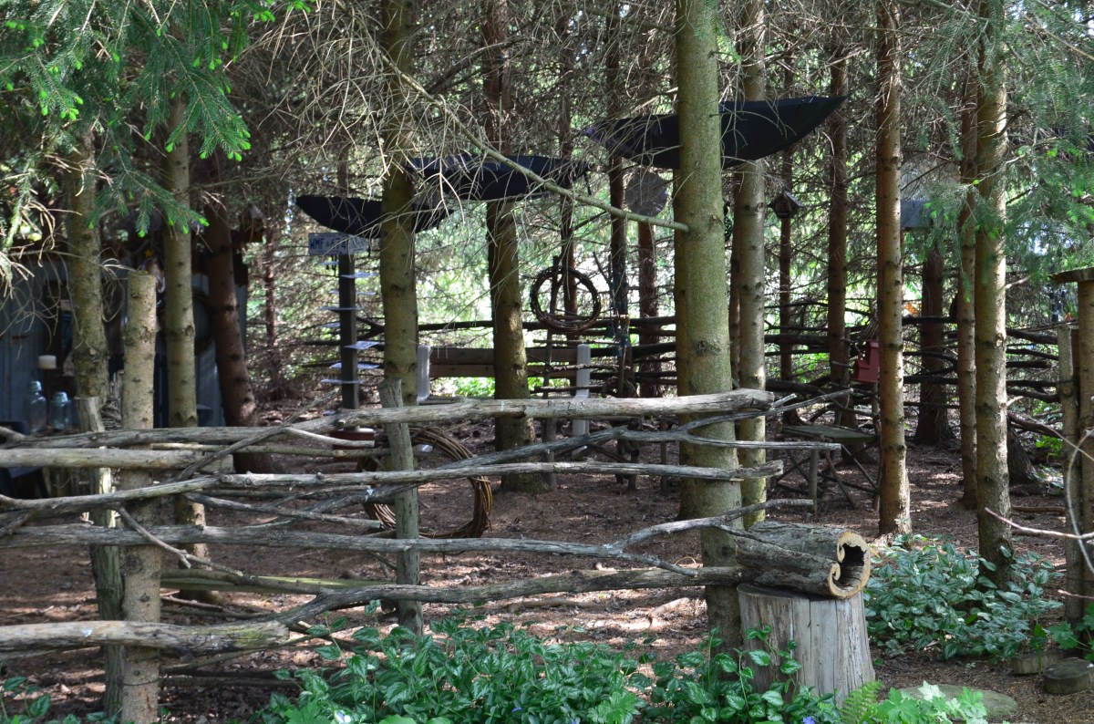 A shady grove for seating includes found art and suspended umbrellas.
