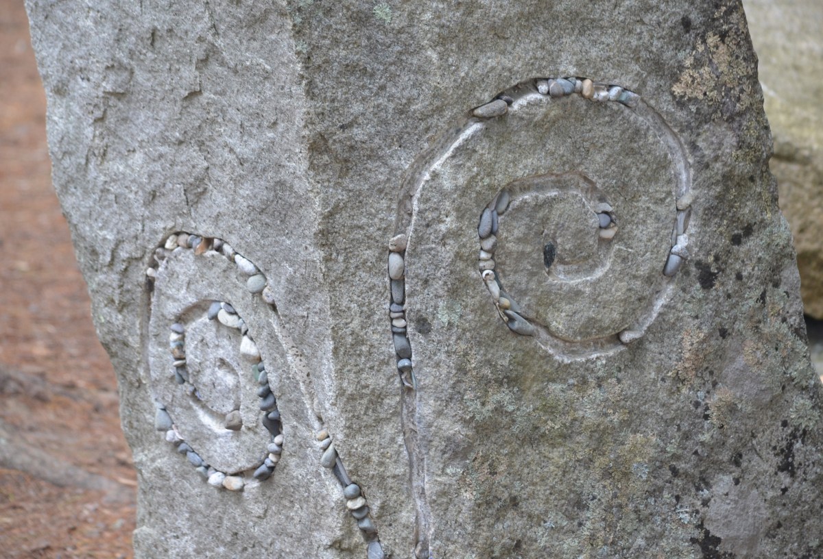 A detail showing a chiseled stone decorated with smaller pebbles