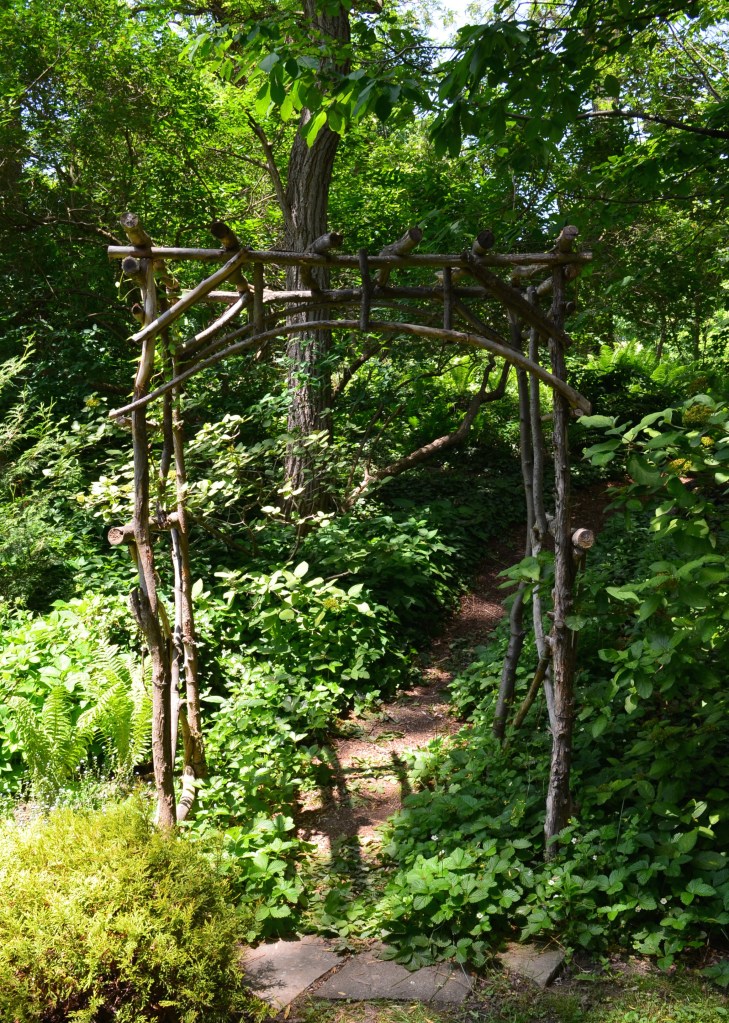 A rustic arbour at the front of a path