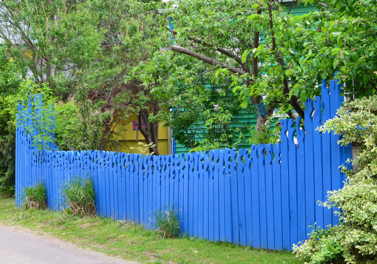 A bright blue fence with carved top