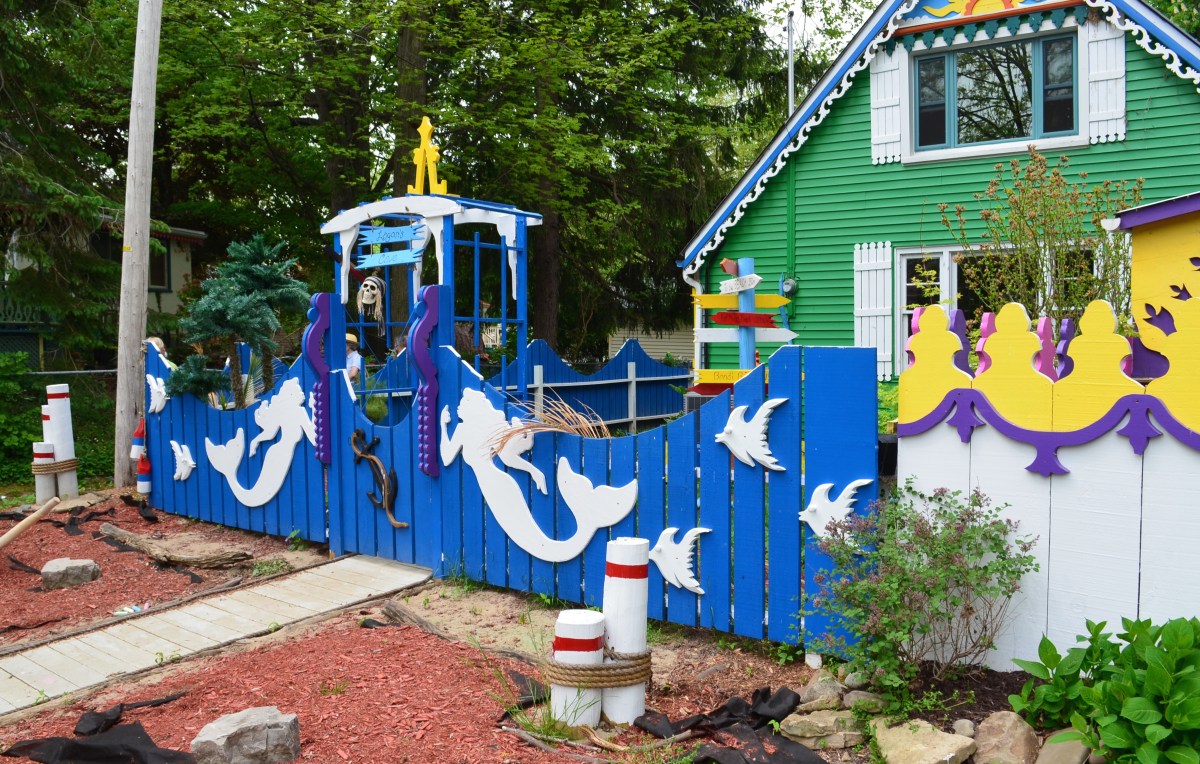 Mermaids decorate a fence with a coastal theme