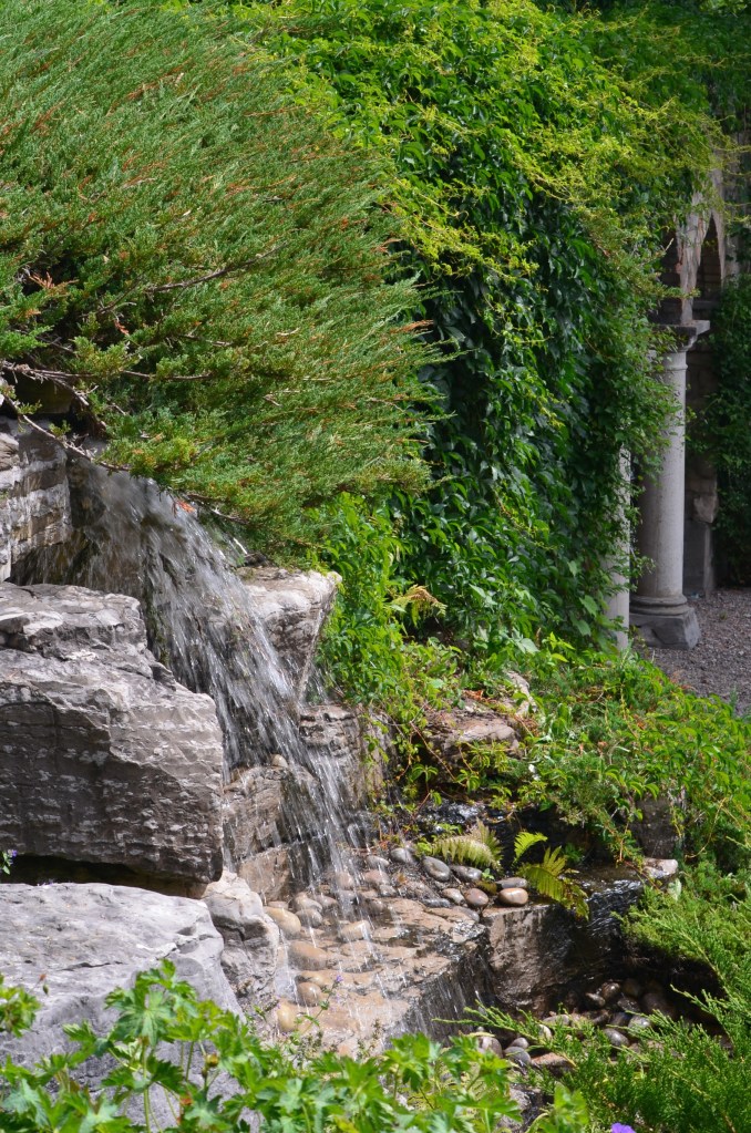 A large water feature is flanked on one side by columns