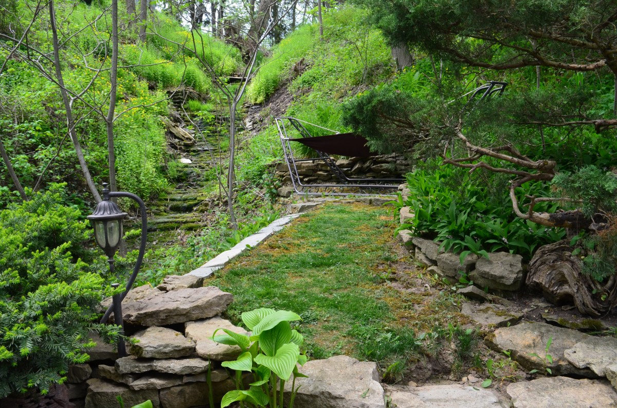 A hammock is sited on the edge of a garden to take advantage of a view of a creek.