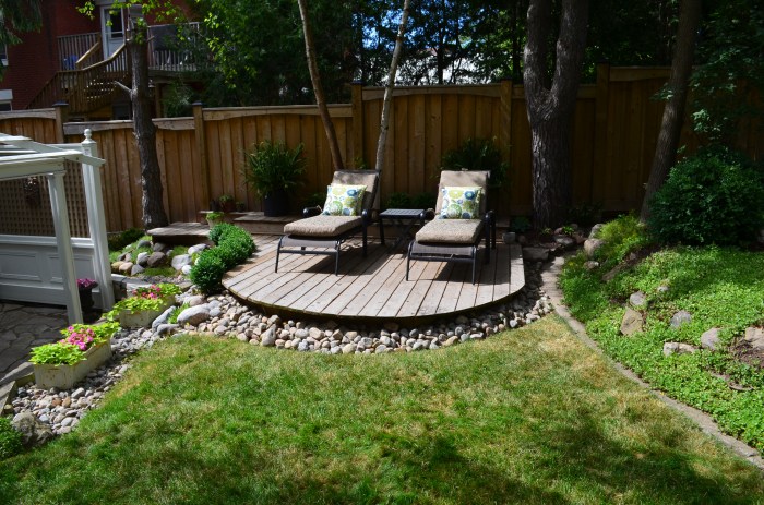 A round deck with two chairs makes a feature in a small garden.