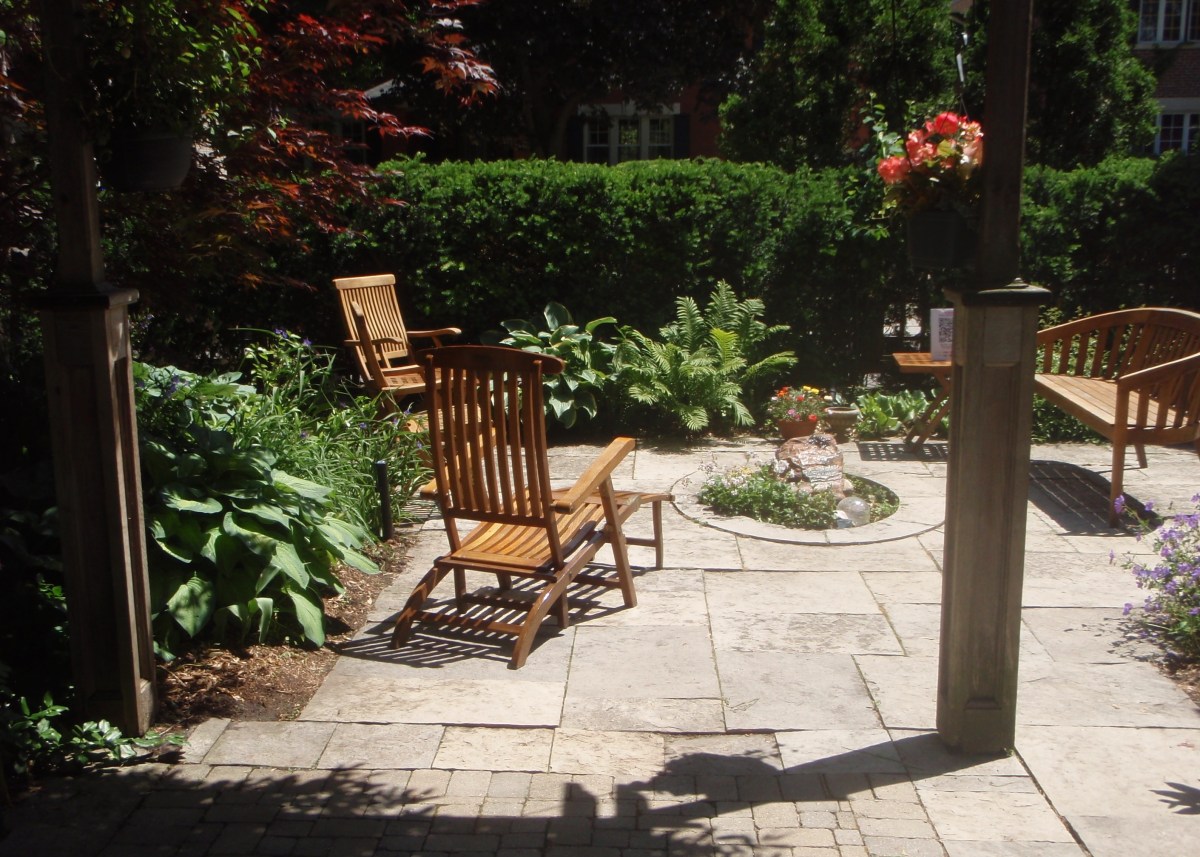 Wooden garden seating around a small water feature in an urban garden.
