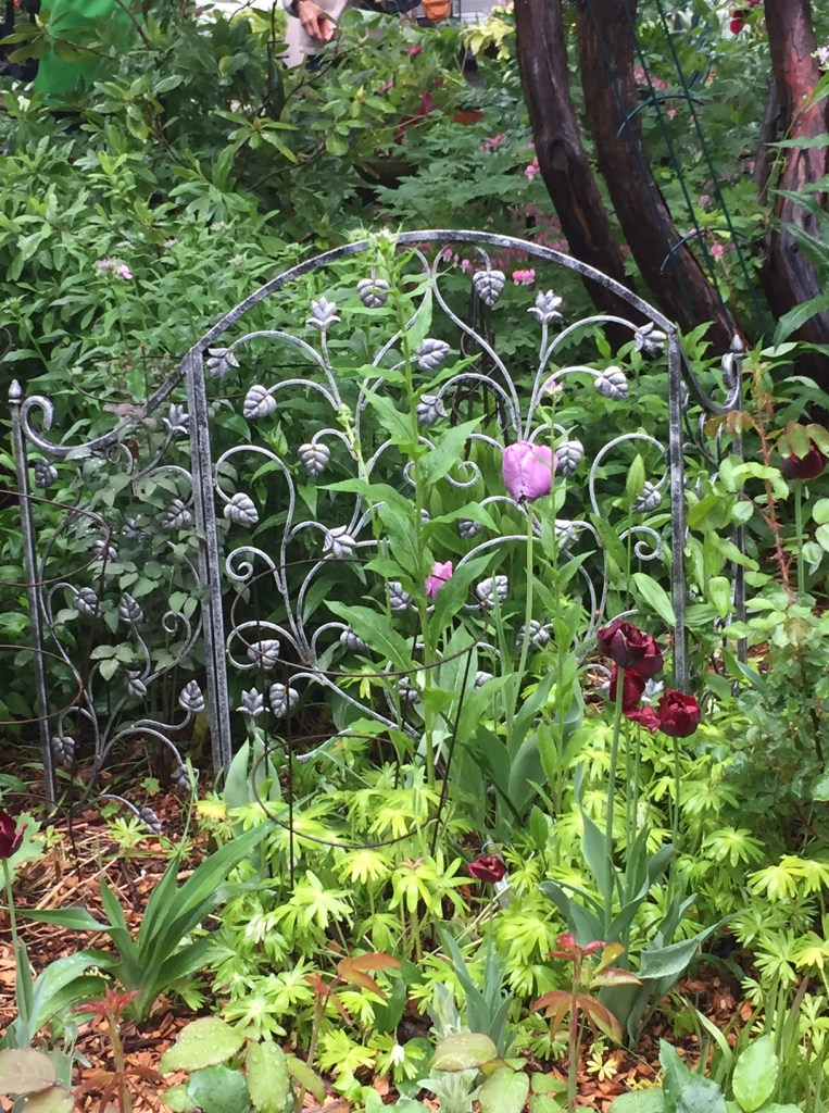 A flowery fire screen creates interest in a flower bed.