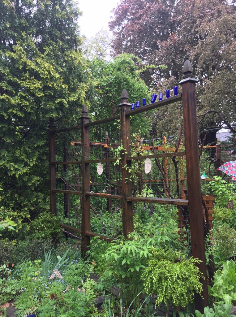 Fanciful fencing creates rooms in a filled back garden.