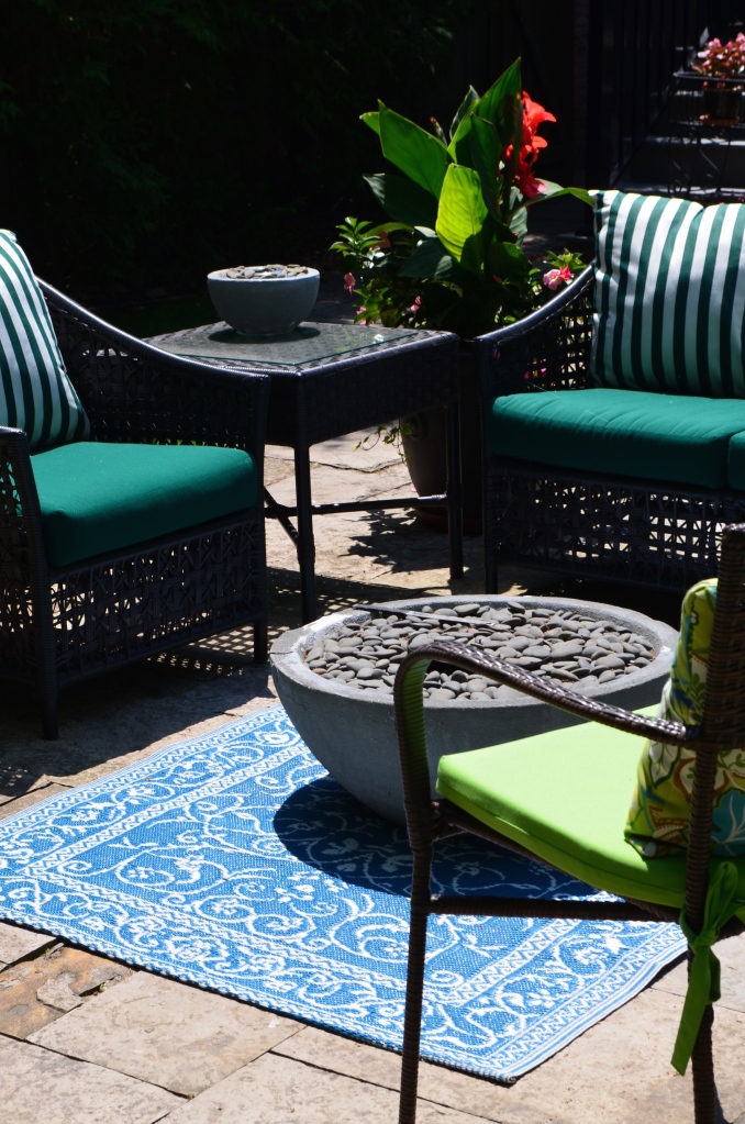 An outdoor carpet brings outdoor furniture in a garden together as a focal point.