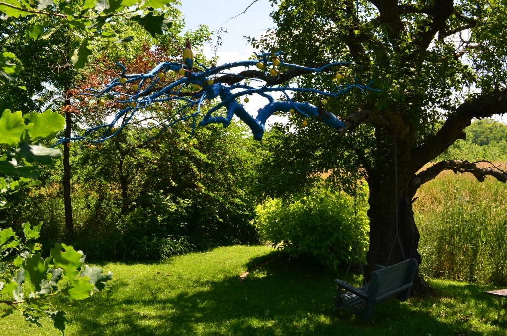 A dead branch painted blue becomes a garden focal point.
