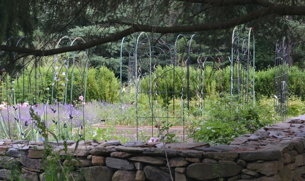 A walled garden gets added height with plant supports.