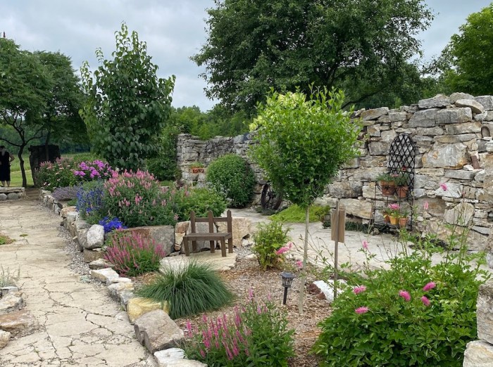 A stone wall protects a garden inside an old barn's foundations