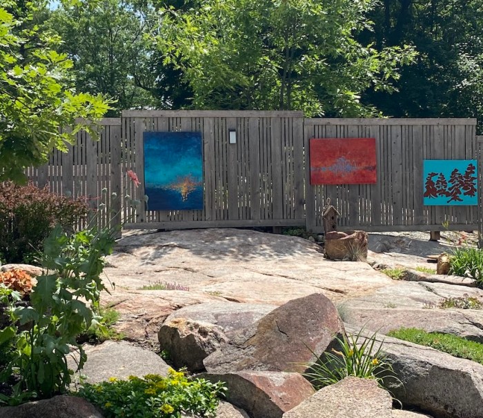Three paintings on a fence
